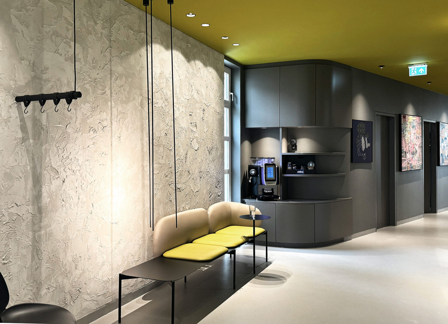 Wartezimmer mit Stil, Kaffeeecke, Betonoptik, schwarze Details verfeinern den Raum, Gelbe Akzente lockern auf, fineconnect Planung