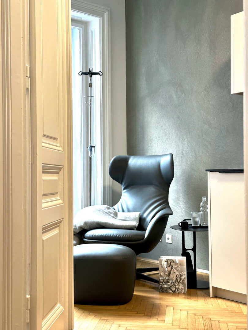 Praxis für Allgemeinmedizin, schwarz gemütlicher Ohrensessel, Innenarchitektur fineconnect.