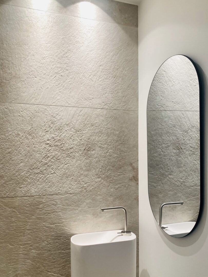 Sanitäranlagen mit Stil - Steinfließen und ovaler Spiegel