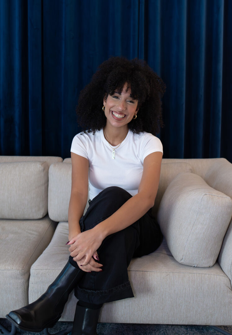 Team von Andrea Gartenmaier-Marianne Awad, professionelle Innenarchitektin in Wien bei fineconnect, sitzend auf beigem Sofa und dunkelblauer Vorhang im Hintergrund